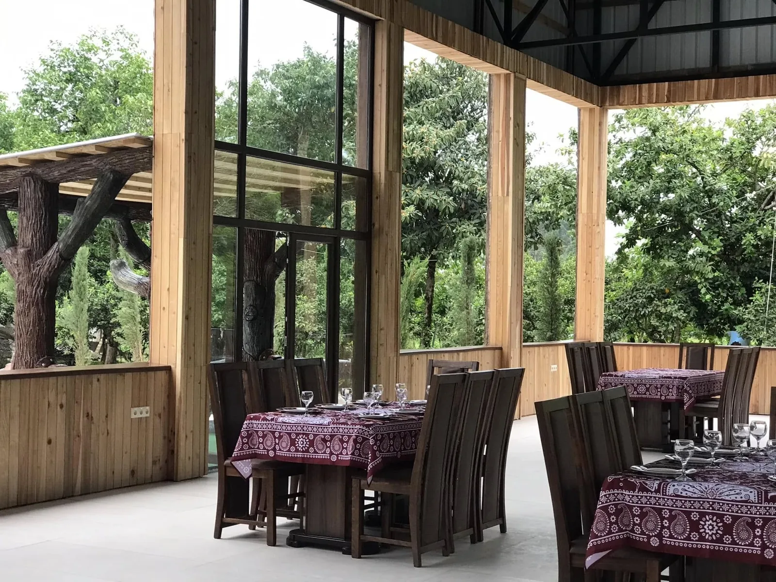 CHAKURA dining hall - long wooden tables under the wood-framed glass walls